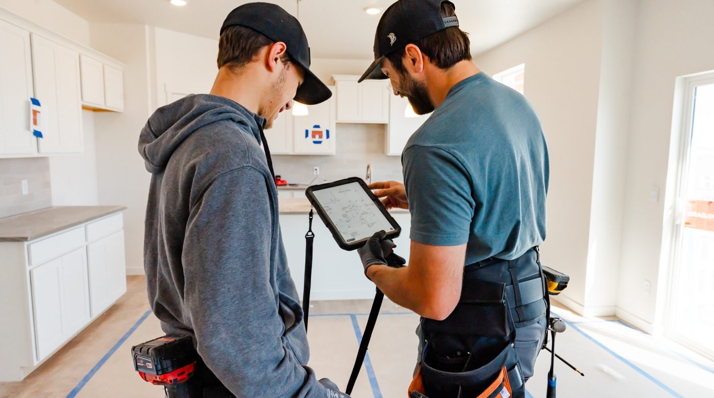 Two Hi Power electricians reviewing electrical plans on a tablet inside a new Douglas County home